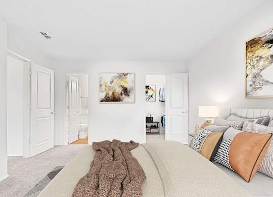 A bedroom with a large bed and a painting on the wall.