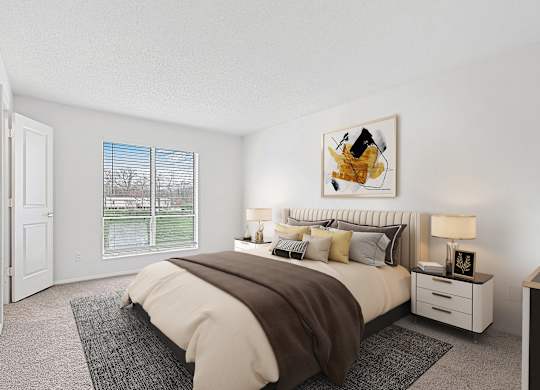 A bedroom with a large bed and a window overlooking a lawn.