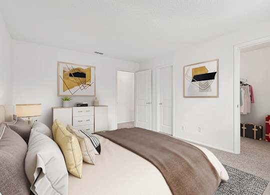 A bedroom with a large bed and two framed pictures on the wall.