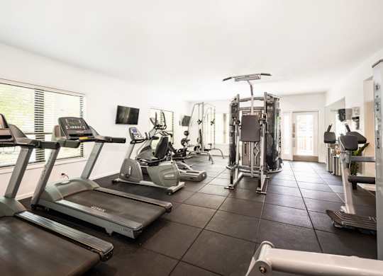 A spacious gym with treadmills, exercise bikes, and other equipment.