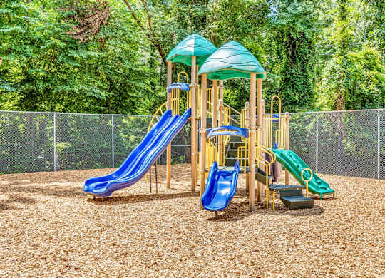 A playground with a blue and green slide and a yellow structure.