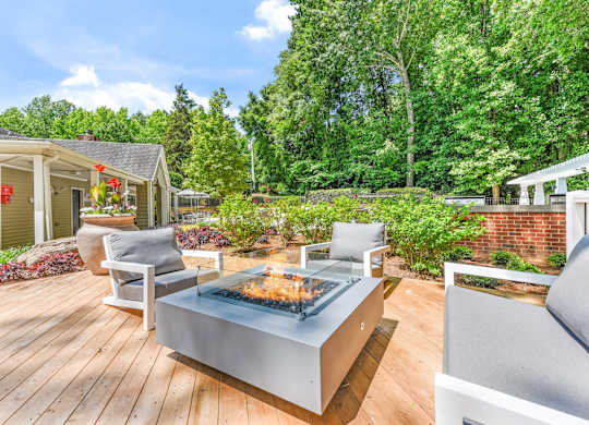 A modern outdoor patio with a fire pit and seating area.