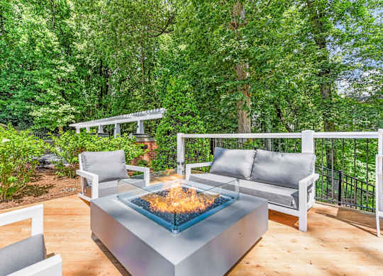 A modern outdoor seating area with a fire pit in the center.
