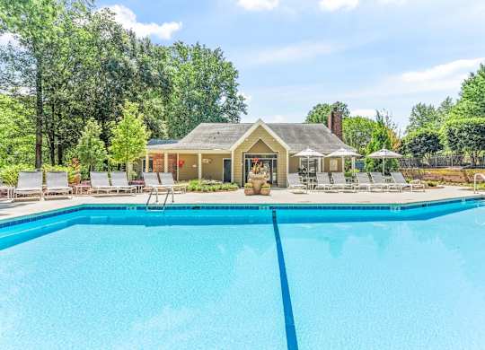 A house with a pool in front of it.
