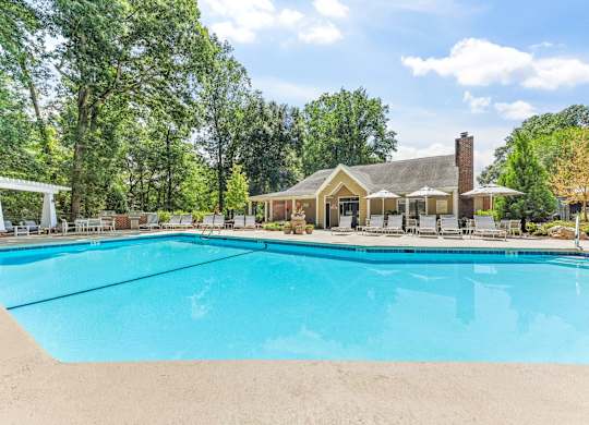 A large swimming pool in front of a house.