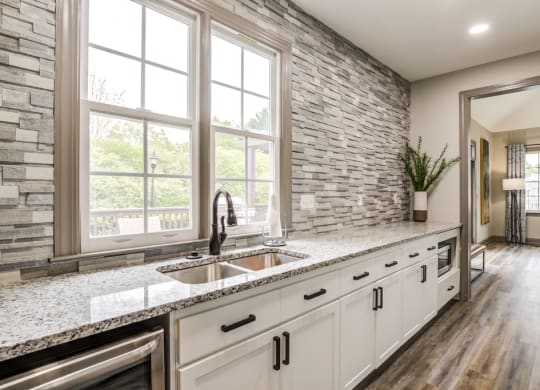 clubhouse kitchen with granite-style countertops and white cabinetry