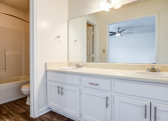 bathroom with white cabinetry and hardwood-style flooring