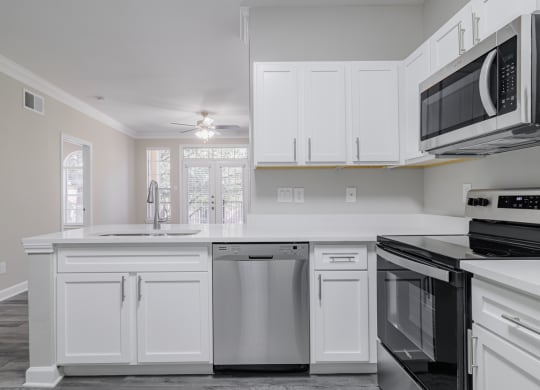 kitchen with white cabinetry, stainless appliances, and hardwood-style flooring