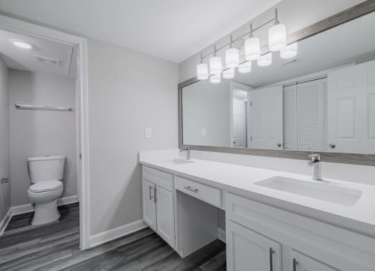 a bathroom with dual vanities, white countertops and cabinetrty