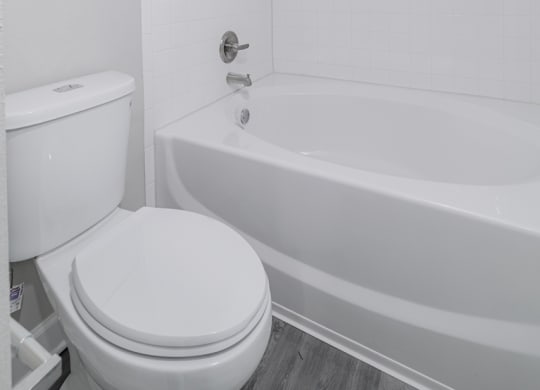 a white bathroom with a toilet and a tub