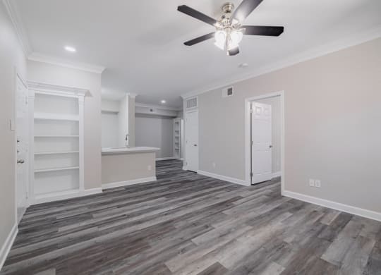 living room with ceiling fan and built-in shelving