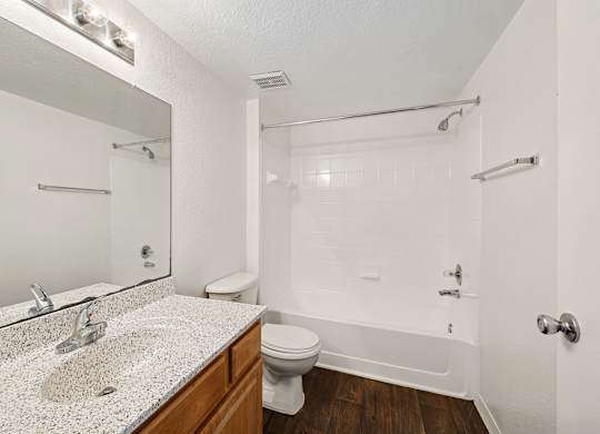 A white bathroom with a sink, toilet, and bathtub.