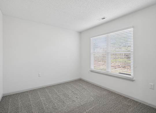 A room with a window covered in blinds.