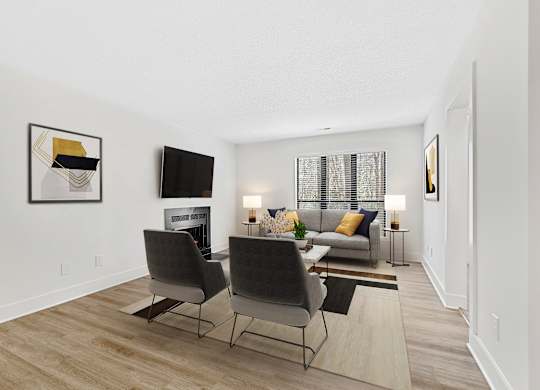 A living room with a grey couch, two chairs and a fireplace. at Woodlyn on the Green Apartment Homes, North Carolina, 27513