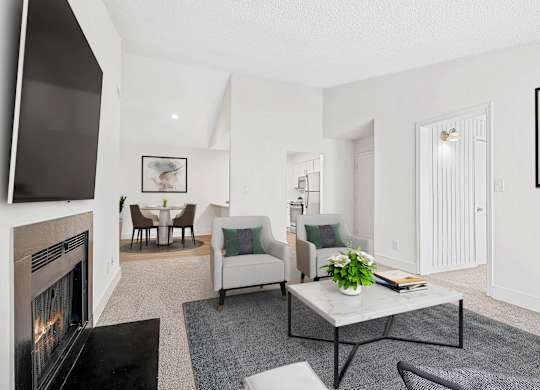 A living room with a fireplace and a couch. at Woodlyn on the Green Apartment Homes, Cary, 27513