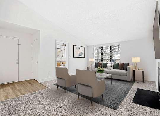 A living room with a grey carpet and a white sofa. at Woodlyn on the Green Apartment Homes, Cary, NC, 27513