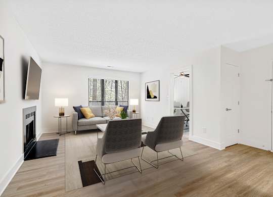 A living room with a fireplace and two chairs. at Woodlyn on the Green Apartment Homes, Cary, NC