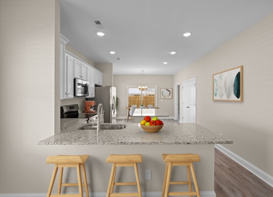 a kitchen with a counter top with three stools