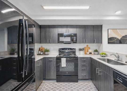 A modern kitchen with a black refrigerator and stove.