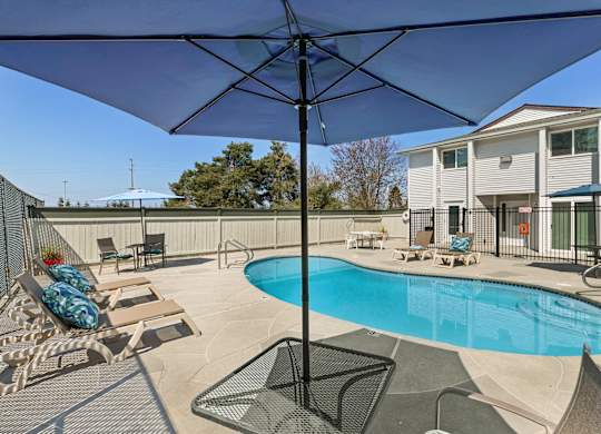 Resort Style Pool with Lounge Chairs and Shaded Bistro Set at Campo Basso Apartment Homes, Lynnwood, 98087