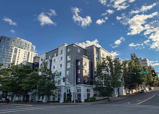 A street view of a white building with a green traffic light.