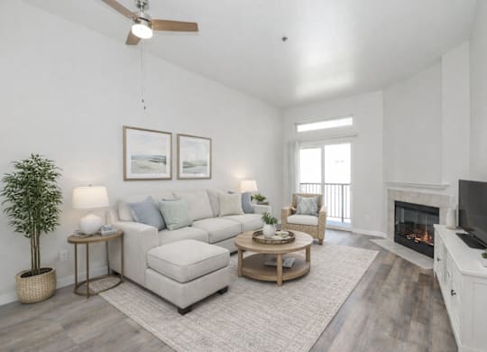 A living room with a fireplace, a couch, a chair, a coffee table, and a television.