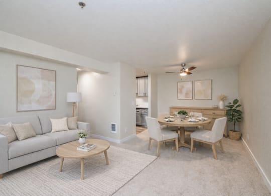 A living room with a couch, a coffee table, and a dining table with chairs.