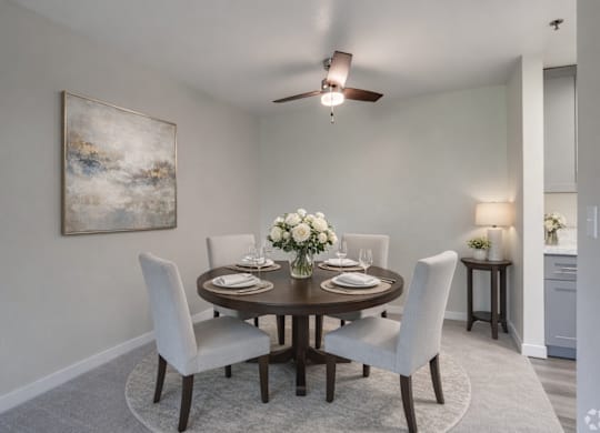 A dining room with a round table set for four.