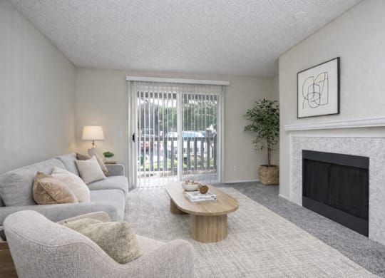 A living room with a grey couch, a coffee table, and a fireplace.