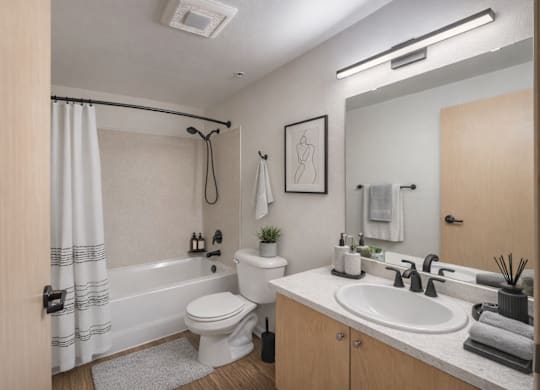 A bathroom with a toilet, sink, and shower.