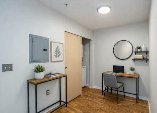 A room with a desk, chair, and a laptop.