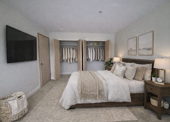 A bedroom with a large bed and a TV on the wall.
