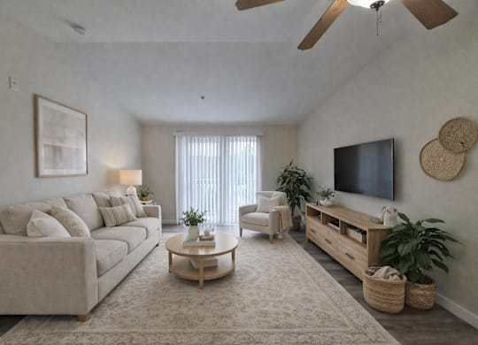 A living room with a beige sofa, a wooden coffee table, a flat-screen TV, and a ceiling fan.