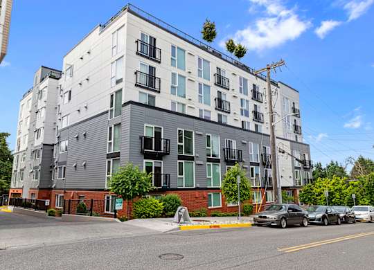 View of the property with grey and brick accents at Arabella Apartment Homes, Shoreline, 98155