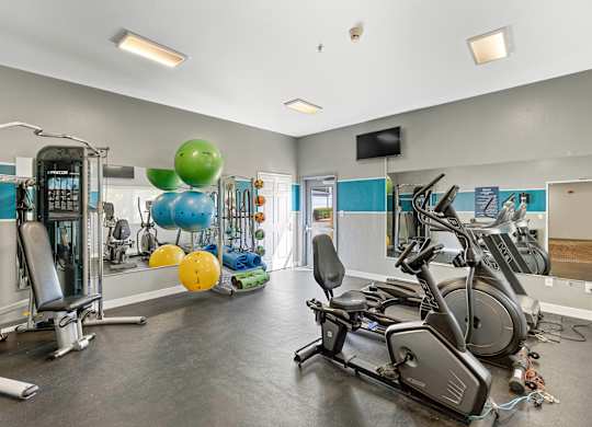a gym with cardio equipment and weights  at Camelot Apartment Homes, Everett, WA, 98204