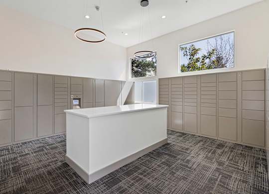 a large room with a counter in the middle and a row of lockers on the wall  at Camelot Apartment Homes, Everett, 98204