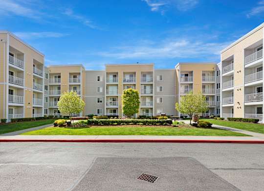 a picture of an apartment complex with a blue sky in the background  at Camelot Apartment Homes, Washington, 98204