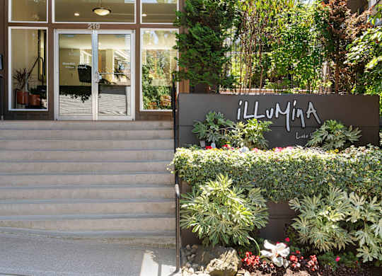 the entrance to the property building with a staircase and plants at Illumina Apartment Homes, Washington