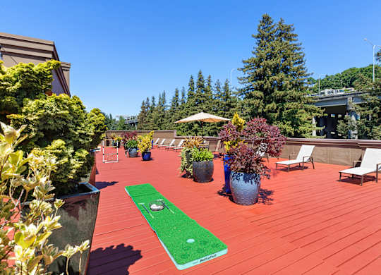 a mini putting green on the resident rooftop deck with trees in the background at Illumina Apartment Homes, Seattle, Washington 98102