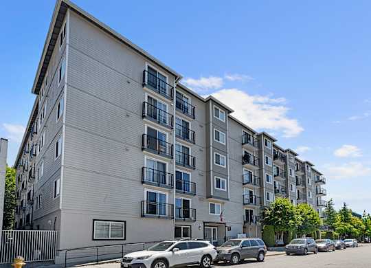 a large apartment building with cars parked in front of it at King Arthurs Court, Seattle, 98125