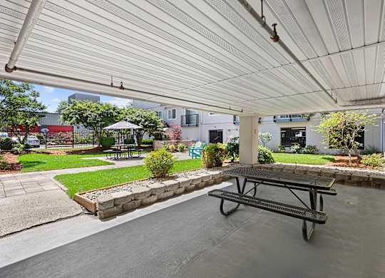a covered patio with a picnic table and courtyard area in the background at King Arthurs Court, Seattle, 98125