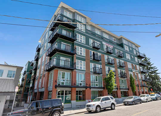 Multi-story property building on the street with cars parked in front of it at Sedona Apartments, Seattle, WA