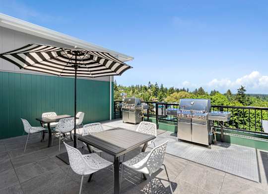 a patio with a table and chairs and a grill  at Sedona Apartments, Seattle, 98115