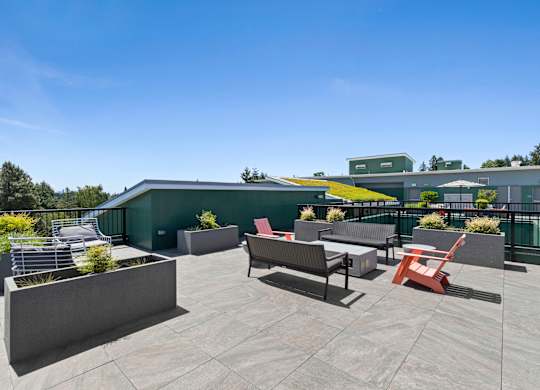 a rooftop patio with a green roof and a variety of seating and tables at Sedona Apartments, Seattle