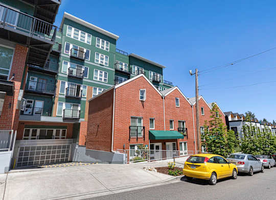 a view from the street of a brick building with a green awning at Sedona Apartments, Seattle