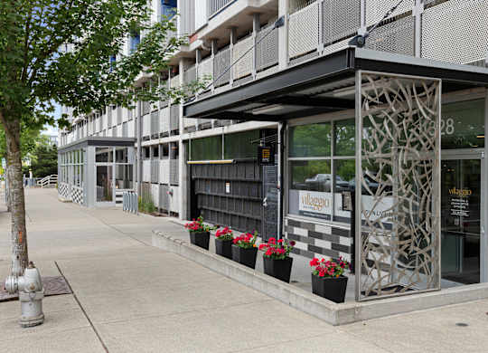 View of the property entrance from the side with artsy iron patio wall at Villaggio Apartment Homes, Tacoma, Washington 98402