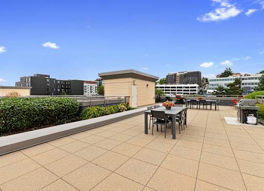 a roof top lounge space with a dining table and chairs at Villaggio Apartment Homes, Washington, 98402