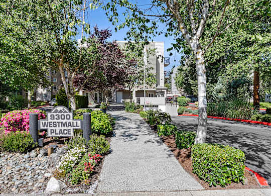 a walkway with small shrubs and property address sign at West Mall Place Apartment Homes, Everett, WA, 98208