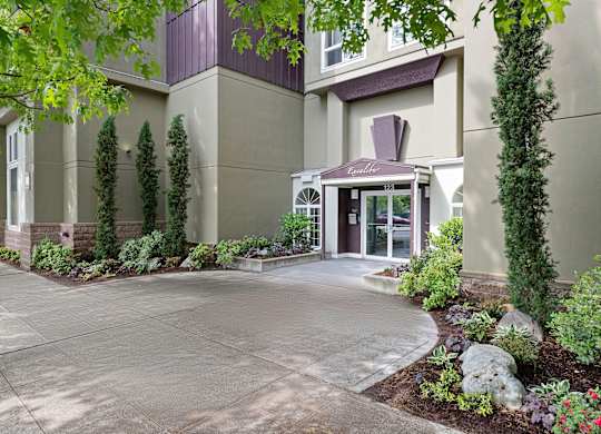 Entrance Image of Apartment Building with Decorative Landscaping to Welcome People In at Excalibur Apartment Homes, Bellevue, WA