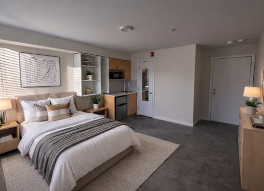 A bedroom with a large bed and a nightstand with a lamp.